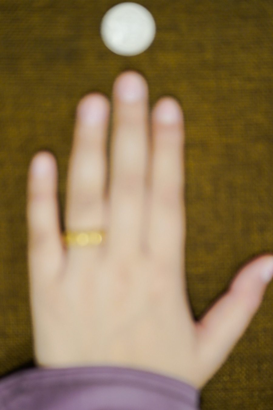 Blurry, out-of-focus hand photo — nail edges not readable